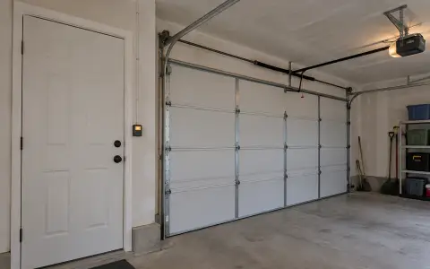 A lighted wall button for the garage door beside the house entry door